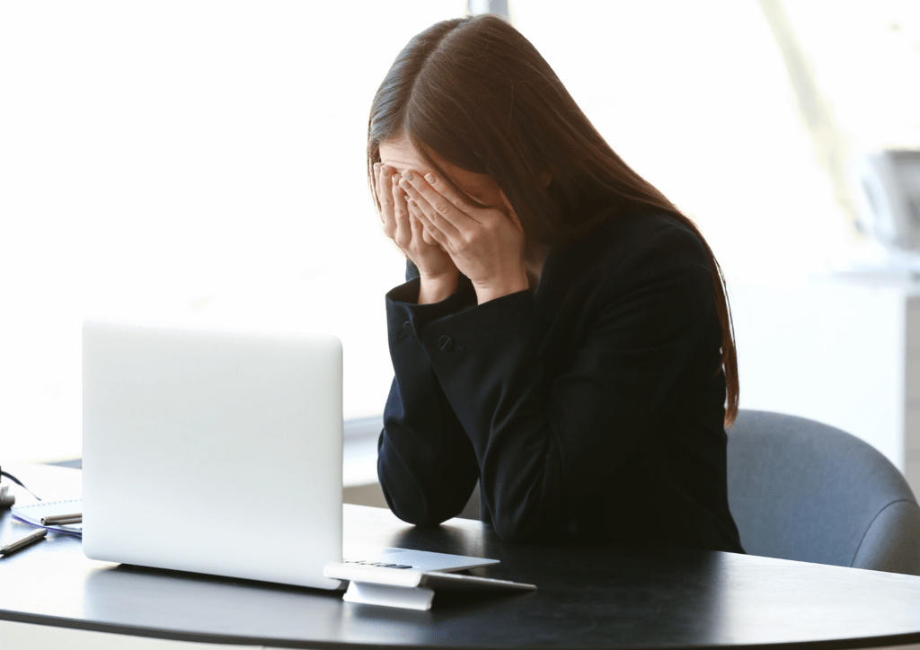 Femme qui pleure à son bureau à cause du harcelement au travail